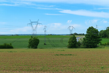 High voltage line electric pylons in the countryside in a field.