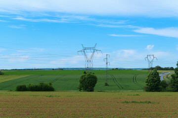 Fototapeta na wymiar High voltage line electric pylons in the countryside in a field.