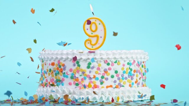Birthday Cake With Burning Colorful Candle with Number 9 on Pastel Background. Falling confetti. Super Slow Motion, 1000 FPS.