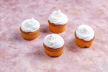 Homemade cupcakes with whipped cream and berries on top.