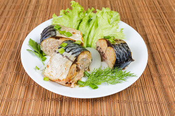 Baked slices of Atlantic mackerel with greens on dish