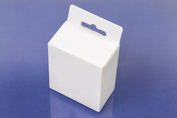 Closed white cardboard hang tab packing box on blue surface