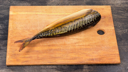 Smoked Atlantic mackerel without head on cutting board, dorsal view