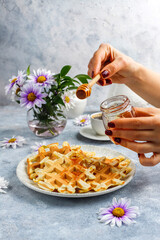 Homemade belgian waffles with honey.