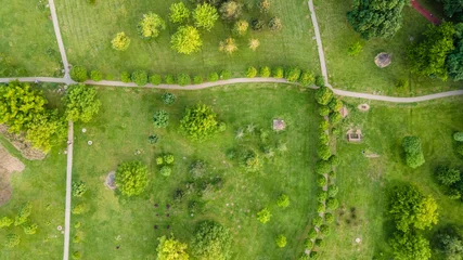 Foto auf Acrylglas Urban park with meadow, trees and paths. Top view aerial photo from flying drone of a city park with walking path and green zone trees in evening time. © Nenad