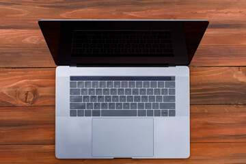 Hightech flat silver luxury notebook computer with lid open is display as isolated on wood background. Top view shot © Bangkok Click Studio