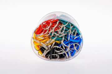 A clear round plastic cylinder box full with branch of metal ring key chain attached with red black yellow and green plastic name tag with white cardboard paper inside. Isolated on white background