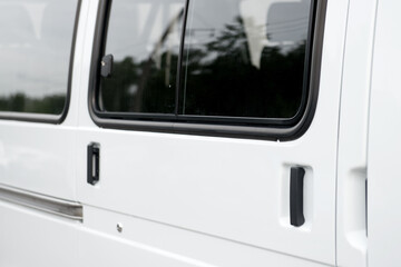 Transparent glass window of the metal door of the minibus. - 436630504