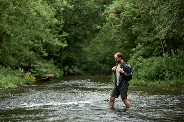 A man in a plaid shirt and green shorts