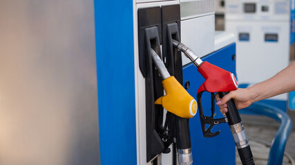 Woman refueling car with gasoline at self-service gas station.