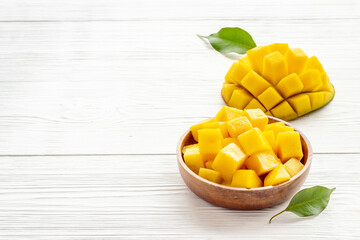 Tropical mango slices and cubes in wooden bowl