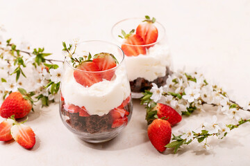 Sweet dessert in glass with biscuit, strawberry and whipped cream