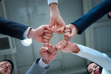 Businessman and woman putting hands fist join together, business partnership colleagues holding...