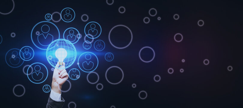 Business and start up concept with bright light bulb in man hand surrounded by digital human figures signs on abstract dark blank background. Mock up - Powered by Adobe