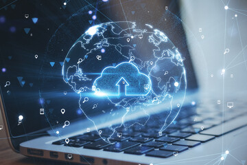 Close up of laptop with abstract glowing globe interface. Cloud computing and security concept. Double exposure.