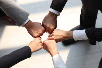 Overhead view of businessman and woman putting hands fist join together, business partnership...