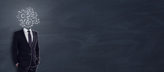 Headless businessman with abstract gear sketch standing on chalkboard background with copy space....