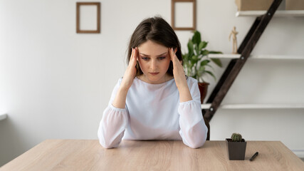 stressed businesswoman feeling strong headache massaging temples exhausted from overwork, fatigued overwhelmed lady executive worker suffering from pain in head or chronic migraine in office