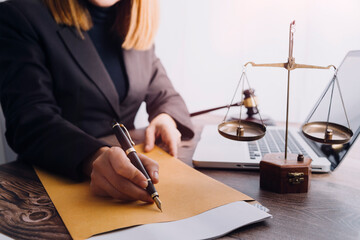 Justice and law concept.Male judge in a courtroom with the gavel, working with, computer and docking keyboard, eyeglasses, on table in morning light