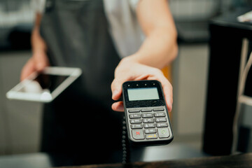 The employee accepts payment by receipt of the invoice. NFC payment in the restaurant. The bartender sells lunches in a paper bag with a customer to take away.