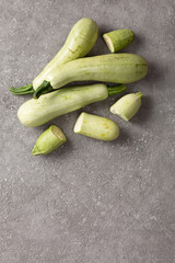 Fresh zucchini on a gray concrete background.