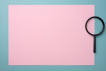 black magnifier on a pink-blue background. The concept of uncertainty and the search for solutions