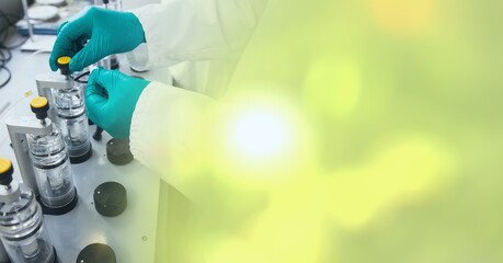 Composition of hands of lab technician at work, with blurred yellow copy space to right