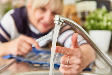 Frau als Heimwerker prüft Temperatur vom Warmwasser