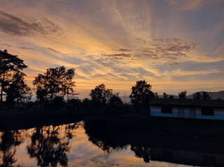Sunset over lake with beatifull view of sky full of clouds  and beatifull reflection of sky and clouds in the water

