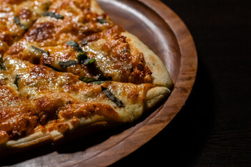 Close up shot of yummy margherita pizza on wooden plate.