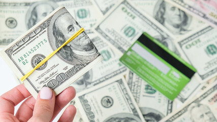 Female hand holding dollars close up. Money currency. Credit card debit card on background. Online...
