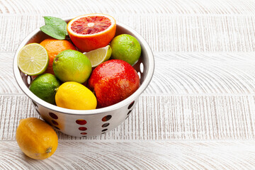 Various fresh citrus fruits in colander. Bood orange, lime, lemon