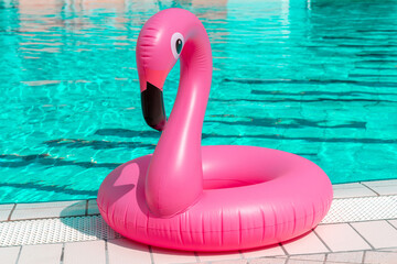 Summer fun isolated. Pink inflatable flamingo in pool water for summer beach background. Funny bird...