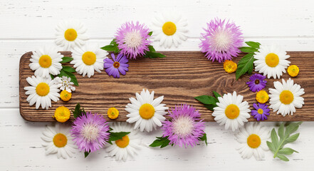 Obraz premium Various garden flowers over wooden background
