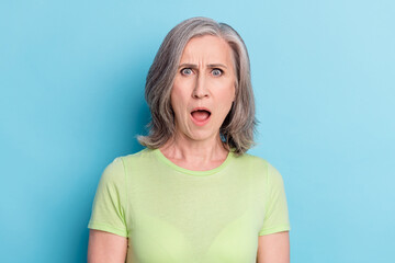 Photo of unhappy shocked astonished old woman reaction fake news isolated on pastel blue color background