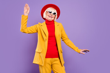 Photo of funny short hairdo elder lady dance wear yellow jacket cap eyewear isolated on purple background