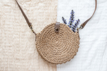 Beautiful handmade knitted round bag made of natural jute material on a white and beige fabric...