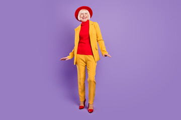 Full body photo of optimistic nice short hairdo elder lady wear yellow suit cap isolated on purple background