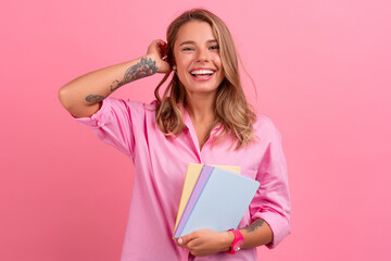 blond pretty woman in pink shirt smiling holding holding notebooks