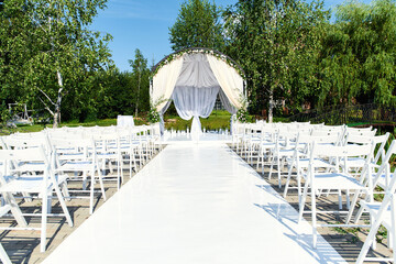 Wedding arch decorated flowers outdoors.