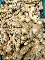 Stack of fresh ginger in food ingredient market
