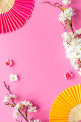 Chinese hand fans with cherry blossom branch. Top view