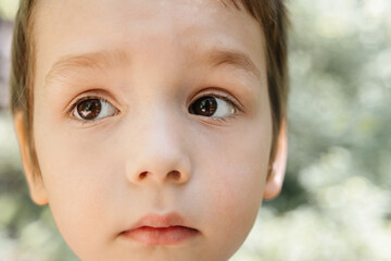A cute little boy with big brown eyes close-up portrait
