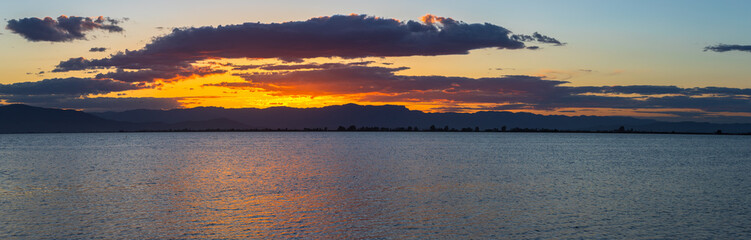 Beautiful sunset-sunrise sky captured in the beach. Golden hour with orange clouds in the sky.