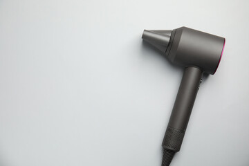 Modern hair dryer on light grey background, top view. Space for text