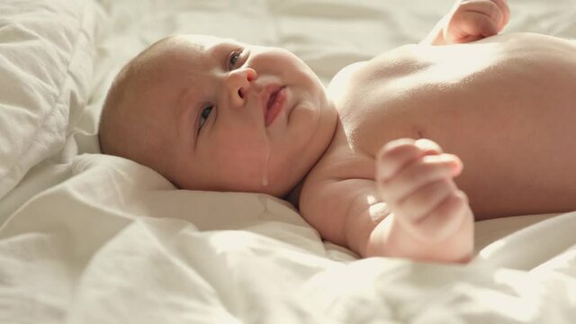 Baby regurgitates breast milk. Little baby crying and mother cleaning her cute face. Authentic Close Up Footage of Adorable Newborn Baby. Concept of Childhood, New Llife, Breast Feeding, Parenthood.