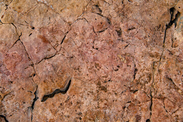 Old stone with cracks on the surface. Rock texture. Natural background