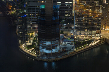 Building under construction at river bend in downtown Chicago at night