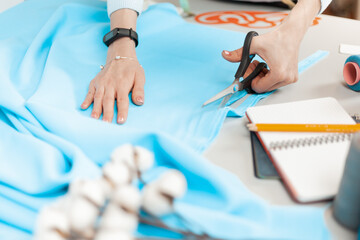 Scissors cut the fabric. Seamstress at work, individual tailoring.