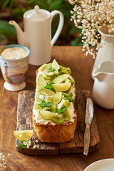Citrus bread garnished with kiwi and lime. Wooden background, side view.
